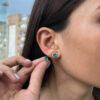 Yellow gold round emerald studs with diamond jackets