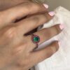 Round Colombian emerald ring with natural ruby halo